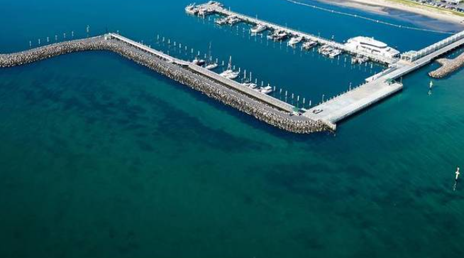 Aerial screenshot of Portarlington Pier and breakwall showing the marina wall, open bay water and darker weed beds for squid fishing
